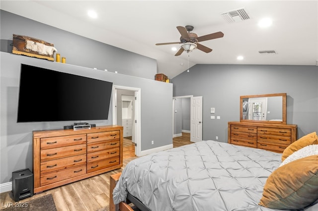 bedroom featuring baseboards, visible vents, lofted ceiling, and light wood-style flooring
