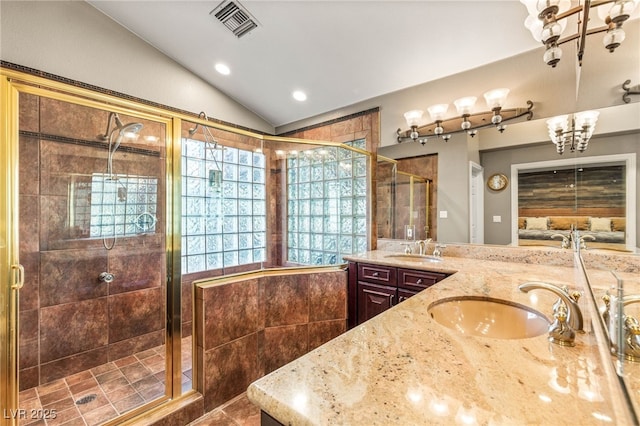 bathroom with a chandelier, a shower stall, vaulted ceiling, and a sink