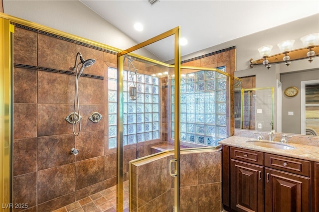 bathroom featuring a stall shower, vanity, and vaulted ceiling