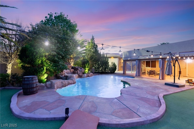 pool at dusk featuring a patio and a fenced in pool