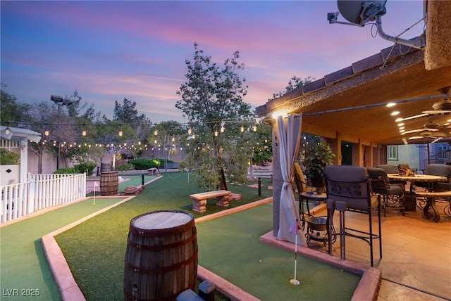 exterior space featuring fence, a ceiling fan, a patio, and an outdoor fire pit