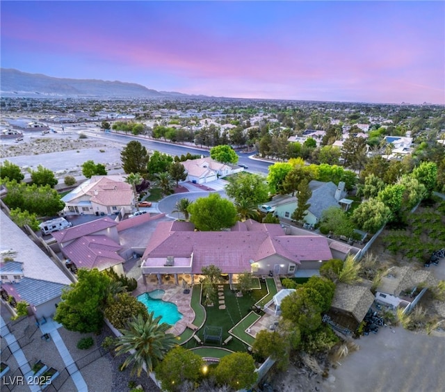 aerial view at dusk featuring a residential view and a mountain view
