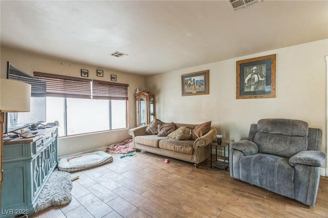 living room featuring visible vents and wood finished floors