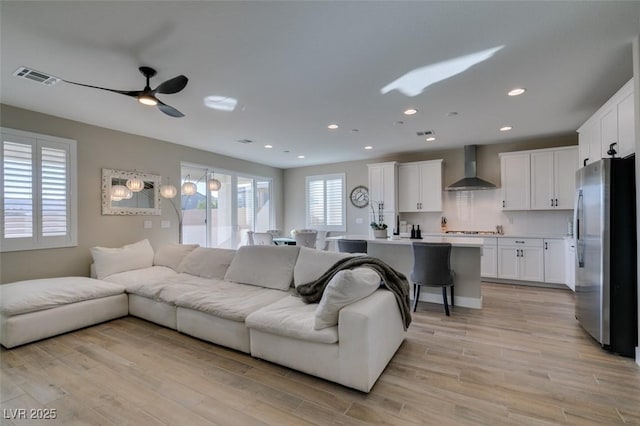 living room with recessed lighting, a ceiling fan, visible vents, and light wood-type flooring