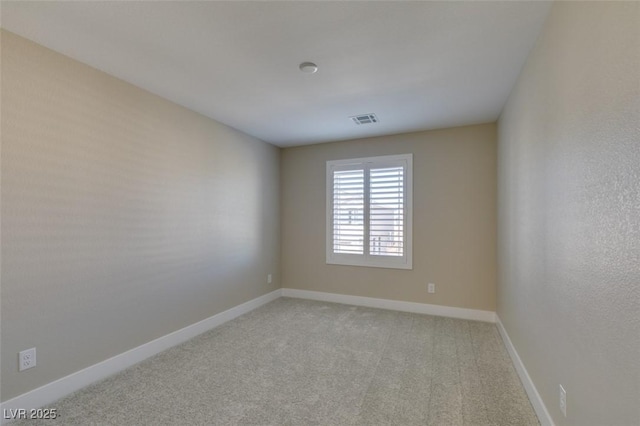 carpeted spare room featuring visible vents and baseboards