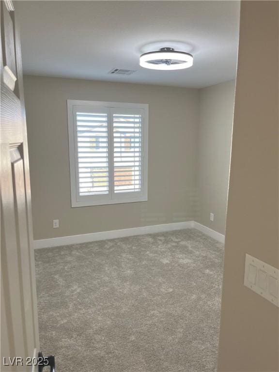 carpeted empty room featuring visible vents and baseboards