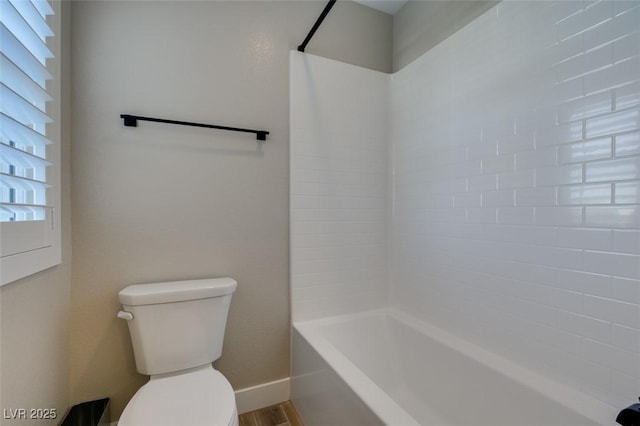 bathroom featuring wood finished floors, toilet, shower / bathtub combination, and baseboards