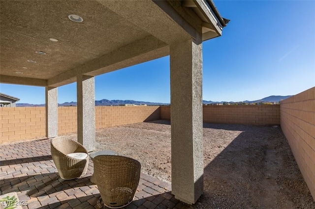 view of patio with a mountain view and a fenced backyard