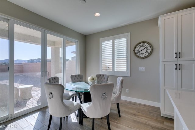 dining area featuring recessed lighting, a mountain view, light wood-style flooring, and baseboards
