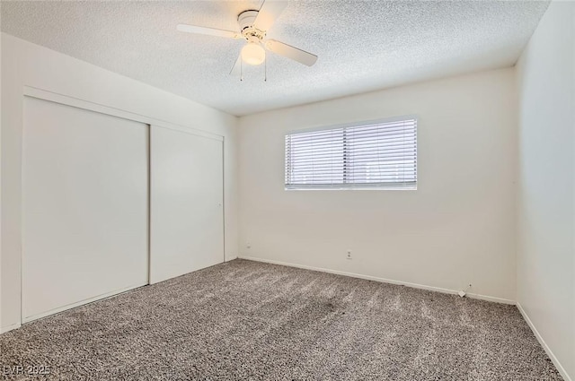 unfurnished bedroom featuring ceiling fan, carpet floors, a textured ceiling, and a closet