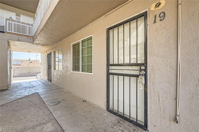 doorway to property with stucco siding and a patio area