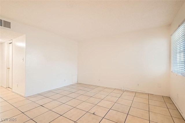 unfurnished room featuring visible vents and light tile patterned flooring