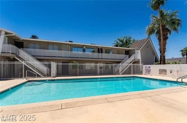 pool with stairs, a patio area, and fence