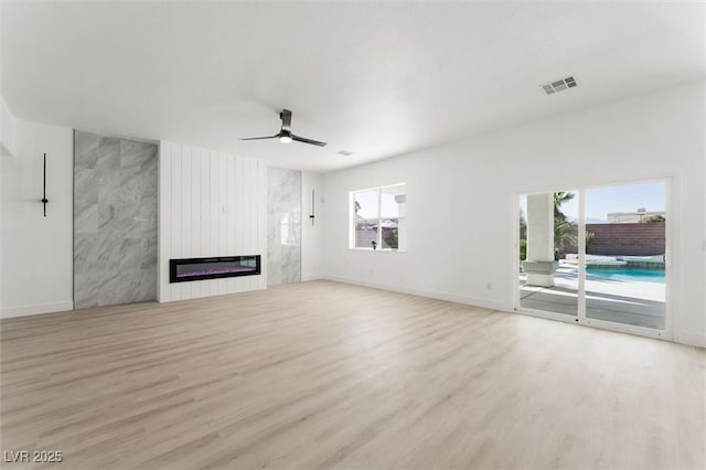 unfurnished living room with a ceiling fan, baseboards, visible vents, and wood finished floors
