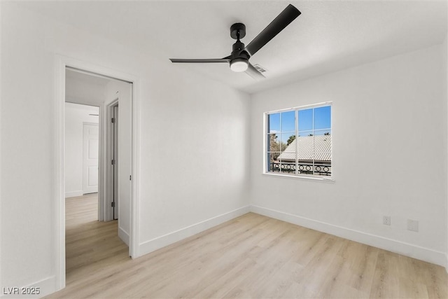 spare room with baseboards, ceiling fan, and wood finished floors