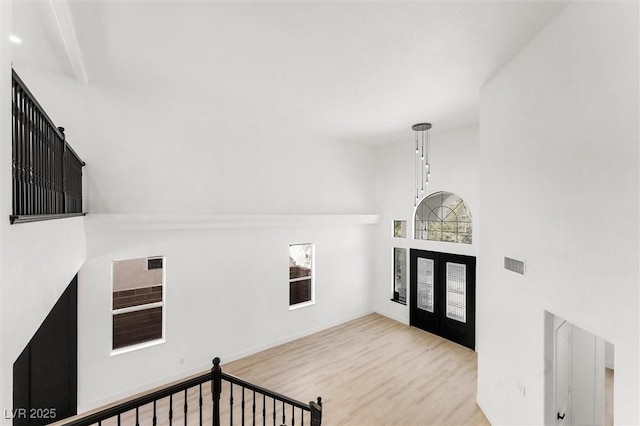 foyer with visible vents, a high ceiling, and wood finished floors