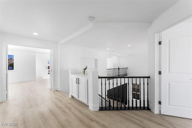 hallway with recessed lighting, light wood finished floors, and an upstairs landing