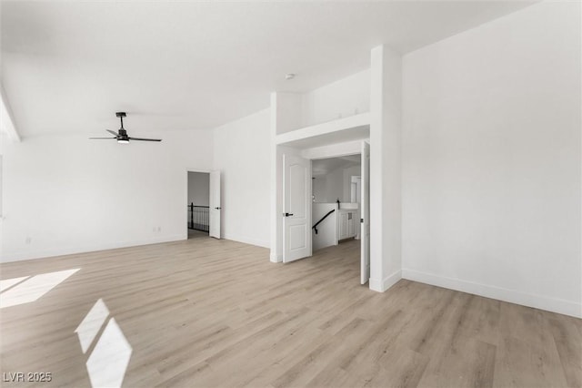 unfurnished living room with light wood-style floors, baseboards, a ceiling fan, and lofted ceiling