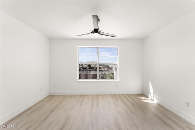 spare room featuring baseboards, ceiling fan, and light wood-style flooring