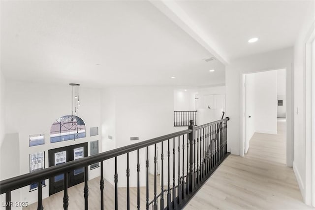 hall featuring recessed lighting, light wood-style flooring, baseboards, and an upstairs landing