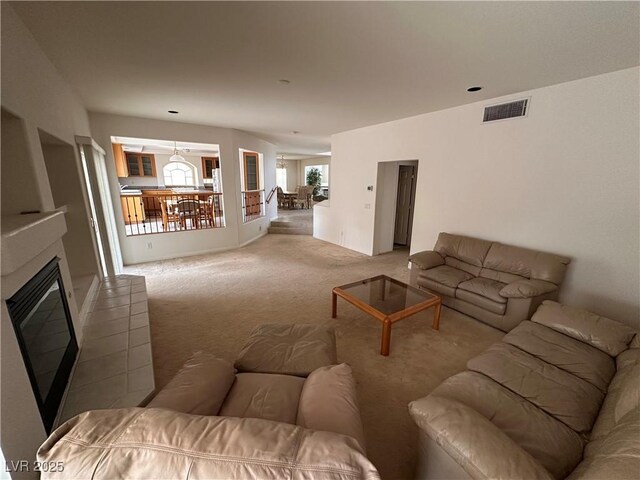 carpeted living room featuring a glass covered fireplace