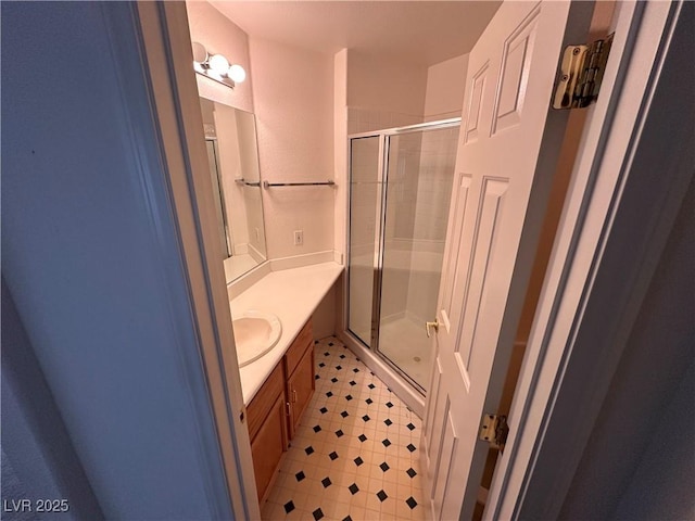 full bathroom with a shower stall, vanity, and tile patterned floors