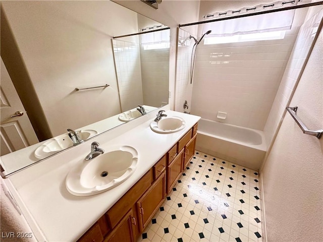 full bath with tile patterned floors, plenty of natural light, double vanity, and washtub / shower combination