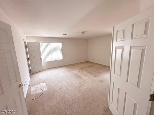 empty room with light colored carpet and baseboards