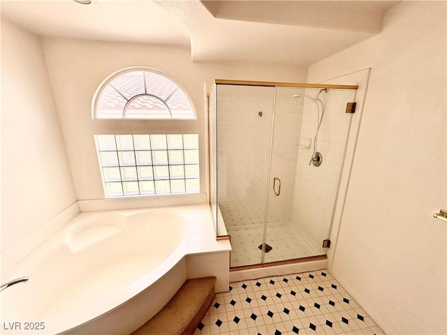bathroom featuring a bath and a stall shower