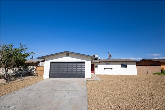 ranch-style house featuring driveway, fence, stucco siding, and an attached garage