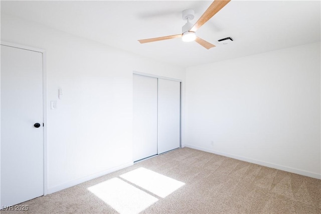 unfurnished bedroom with a closet, baseboards, a ceiling fan, and carpet floors