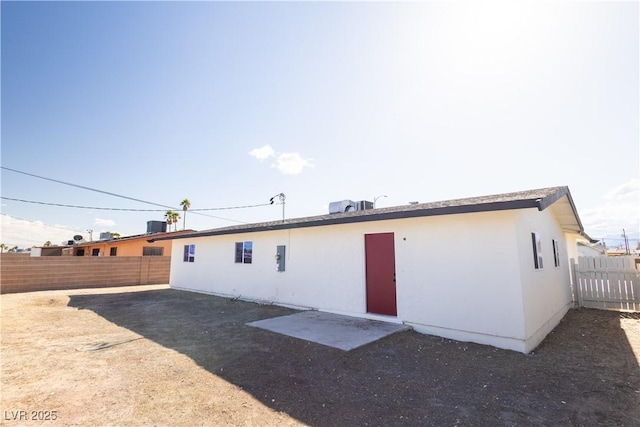 rear view of property with cooling unit, stucco siding, and a fenced backyard