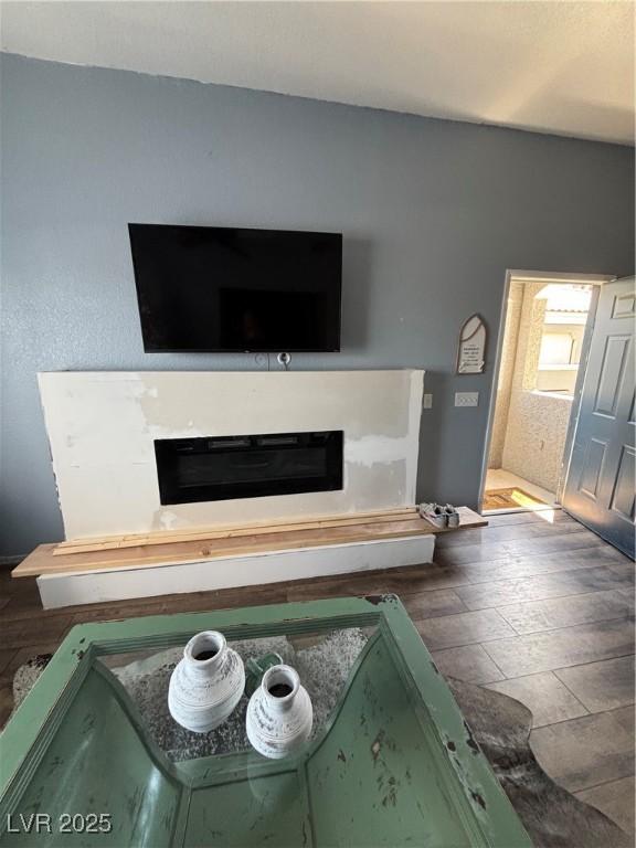 details with wood finished floors and a glass covered fireplace