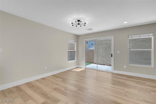 unfurnished room featuring visible vents, light wood-style floors, baseboards, recessed lighting, and a notable chandelier
