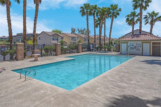 community pool with a residential view, a patio area, and fence