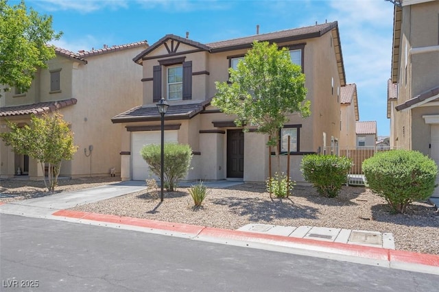 view of front of property with a tile roof, a garage, stucco siding, and fence