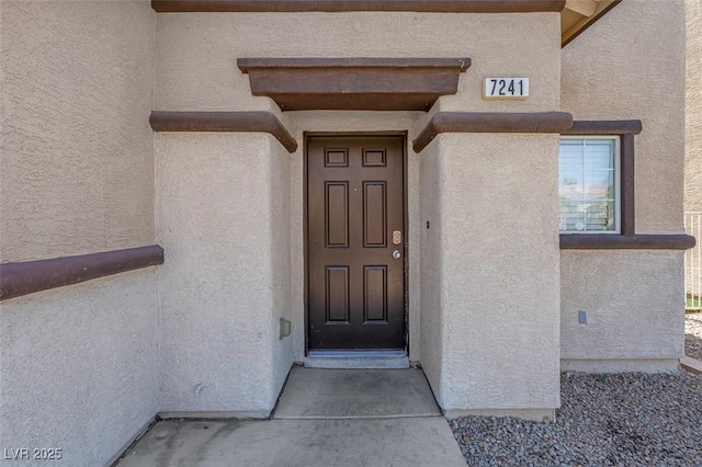 property entrance featuring stucco siding