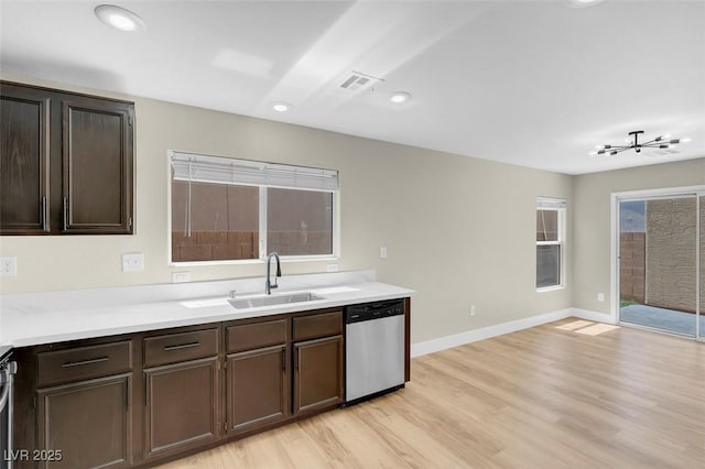 kitchen featuring a sink, light wood-style floors, visible vents, dishwasher, and dark brown cabinets