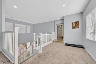 interior space with carpet flooring, recessed lighting, baseboards, and an upstairs landing