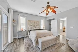 bedroom featuring a ceiling fan, baseboards, and wood finished floors