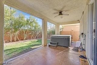 view of patio / terrace featuring a fenced backyard, ceiling fan, and a hot tub