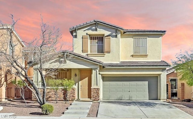 view of front of home featuring concrete driveway, stucco siding, and a garage