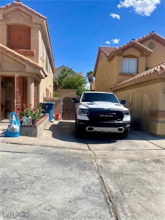 6429 Rosemount Ave, Las Vegas, NV 89156 - view of property exterior featuring a tile roof, a gate, stucco siding, and driveway