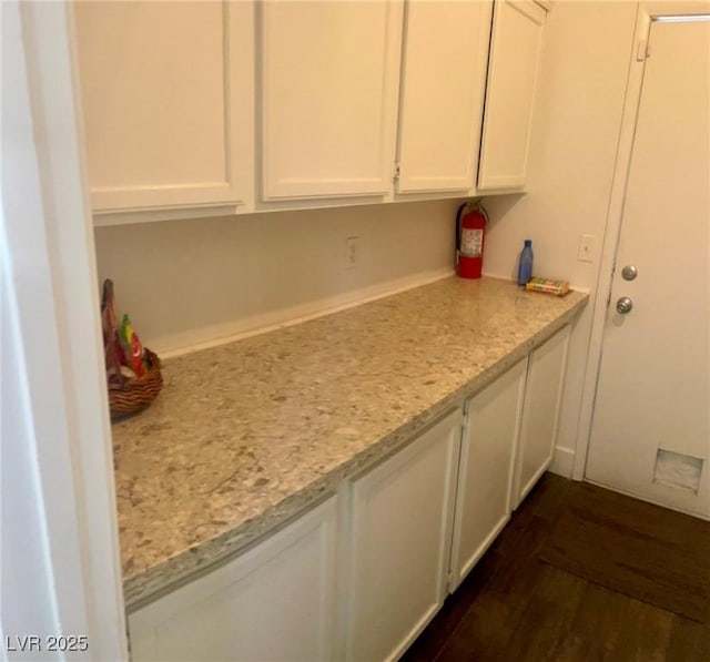6429 Rosemount Ave, Las Vegas, NV 89156 - kitchen with white cabinets, dark wood-style flooring, and light stone countertops