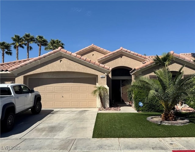 mediterranean / spanish home featuring driveway, a tile roof, an attached garage, stucco siding, and a front lawn