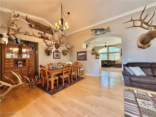 2986 Matese Dr, Henderson, NV 89052 - dining room featuring arched walkways, baseboards, a chandelier, ornamental molding, and light wood-style flooring