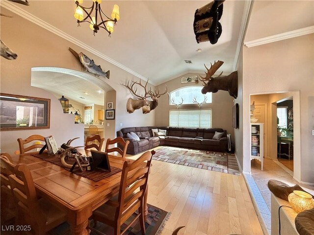 2986 Matese Dr, Henderson, NV 89052 - dining room with arched walkways, wood-type flooring, lofted ceiling, an inviting chandelier, and ornamental molding