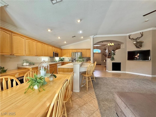 2986 Matese Dr, Henderson, NV 89052 - kitchen with appliances with stainless steel finishes, light countertops, arched walkways, light tile patterned floors, and ornamental molding