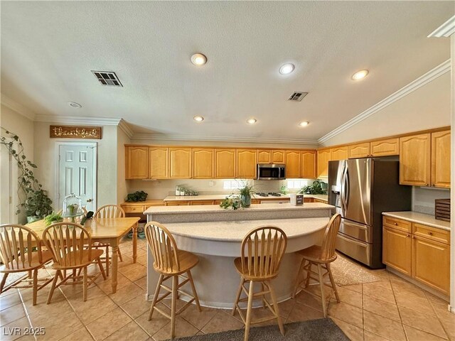 2986 Matese Dr, Henderson, NV 89052 - kitchen featuring light tile patterned flooring, light countertops, stainless steel appliances, a kitchen island, and ornamental molding