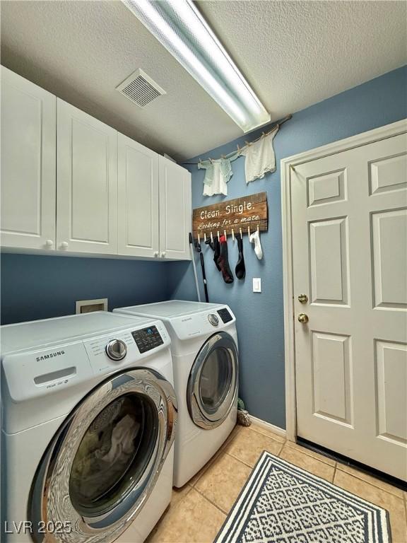 2986 Matese Dr, Henderson, NV 89052 - laundry room with visible vents, washing machine and dryer, a textured ceiling, cabinet space, and light tile patterned floors